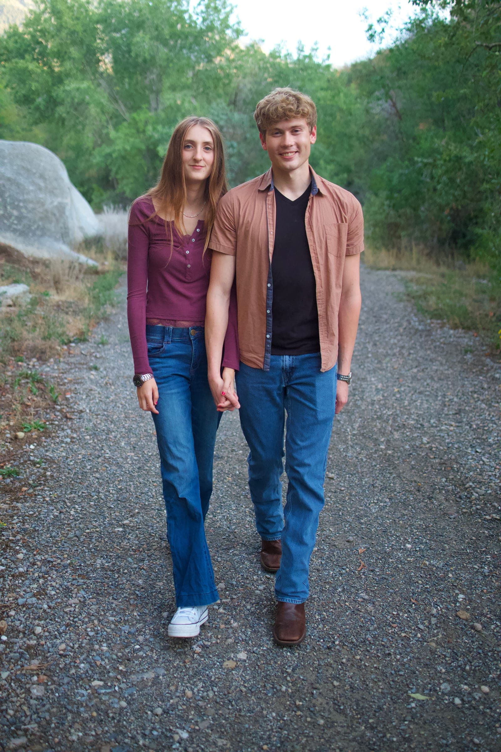 Molly and Tyler walking down a gravel canyon path holding hands