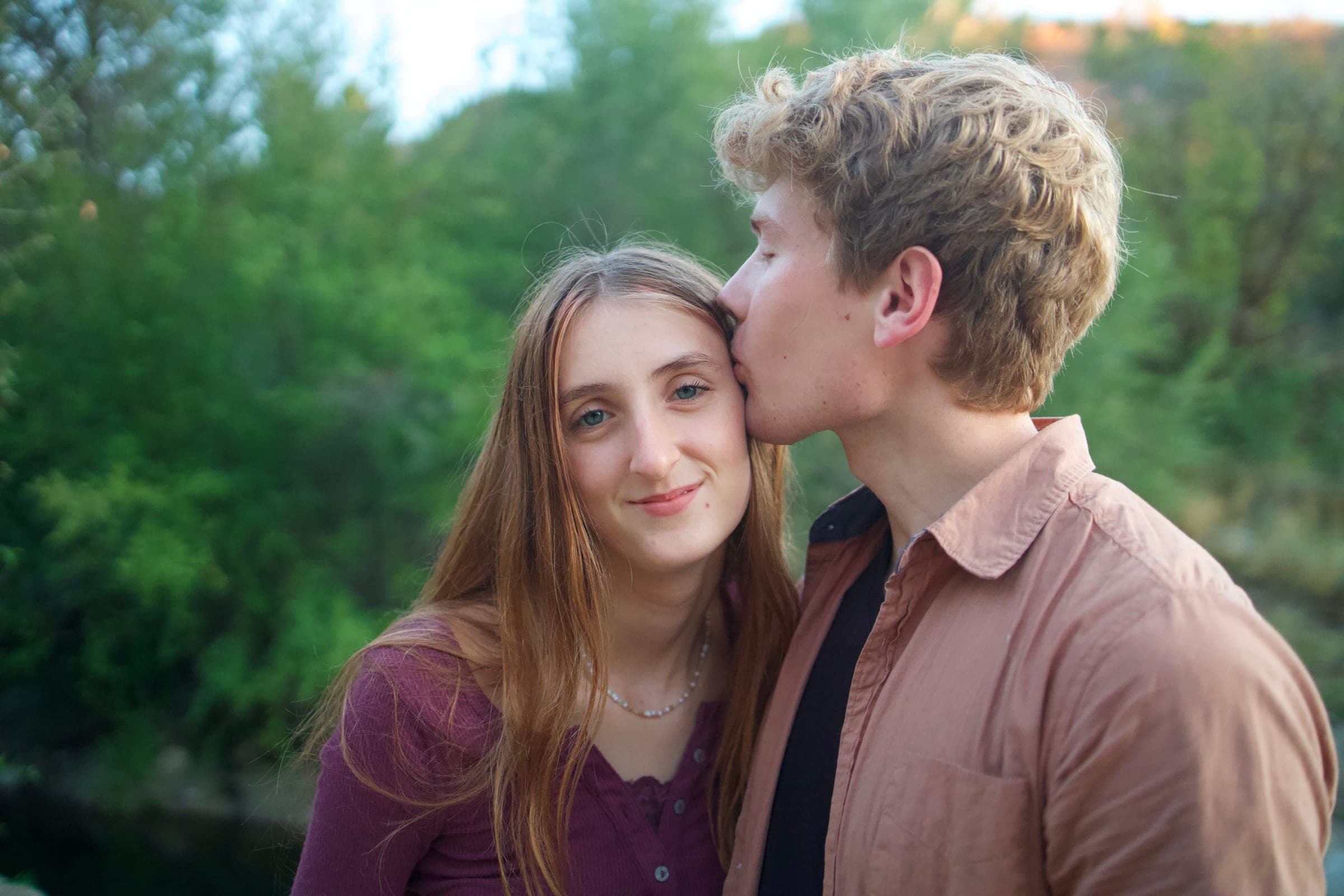 Tyler kissing Molly on the cheek by the river